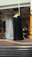 Vertical Close up of spray cans in empty basement with graffiti drawings on walls. Focus on paint cans with underground warehouse used as crime haven by hooligans in blurry background video