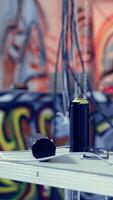 Vertical Close up of spray cans used by guerilla artists in building with graffiti drawings sprayed on walls. Paint cans in desolate industrial location used by teens to do art, concept of urban culture video