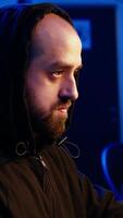 Vertical Hacker hiding in underground bunker excited after developing zero day exploit undetectable by antivirus. Malicious man successfully tricks firewalls, celebrating accomplishment, camera A close up video