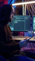 Vertical Hackers doing computer sabotage using encryption trojan ransomware on tablet. Cybercriminals use device to demand ransom money from victims in exchange for access to their data, zoom in shot video