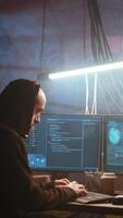 vertical hacker dentro nebuloso néon iluminado porão com grafite desenhos em paredes usando avançado tecnologia computador, corrida código. cibercriminoso usando Sombrio subterrâneo armazém Como crime refúgio, Câmera b video