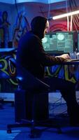 Vertical Hacker in hidden base successfully getting past anti tamper measures implemented by companies to protect products. Cracker pirating software and game releases, camera A handheld camera shot video