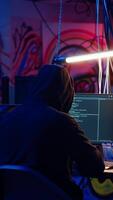 Vertical Revealing shot of spy using VPN and darknet as anonymity tools to mask online identity while stealing governmental secrets. Man in underground bunker masks his location, committing espionage, camera B video