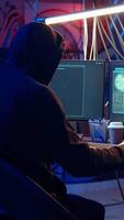 Vertical Evil cybercriminal in hidden base targeting vulnerable unpatched connections, getting past computer defenses and stealing data, dolly in shot. Hacker destroying firewalls and infecting computers video