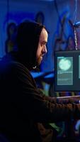 Vertical Hacker happy after successfully doing computer sabotage using encryption trojan ransomware in hidden base. Cybercriminal demands ransom money from victims after gaining access to their data, camera A video