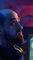 Vertical Hacker hiding in underground bunker, looking over his shoulder and feeling anxious after stealing data from victims using computer virus, scared about being caught by police, camera B close up video