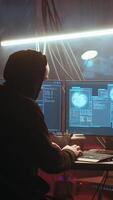 Vertical Hacker using high tech computer system to run malicious code in foggy dark basement. Rogue programmer committing illegal activities using PC in neon illuminated criminal hideout, camera B video