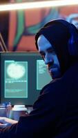 Vertical Hacker doing international espionage warfare for his government to steal state secrets from another countries, anxiously looking over shoulder, afraid of being caught and going to jail, camera B video