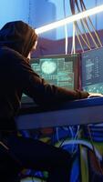 Vertical Malicious man hacking and talking on phone with partner, stealing credit card numbers, manipulating banking systems. Evil hacker runs dangerous code, chatting with friend in telephone call, camera A video