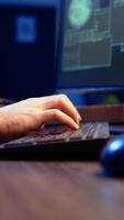 Vertical Meticulous hacker typing on computer keyboard, doing data breaches and financial theft in dark bunker. Close up shot on cybercriminal stealing users bank account credentials, camera A video