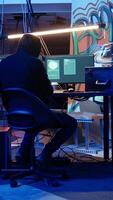 Vertical Hacker leaving secret base with suitcase full of money and stolen data obtained from victim after blackmailing with ransomware. Cybercriminal finishing criminal plan, exiting basement, camera A video