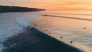 Drone view of surfers with surfing waves at sunset. Perfect swell waves in ocean at Bali, Impossibles beach video