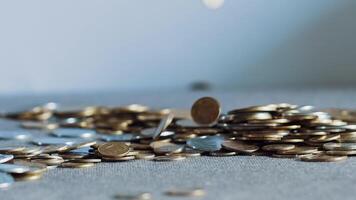 large number of coins dropping on to a table and filling the surface. Close Up video