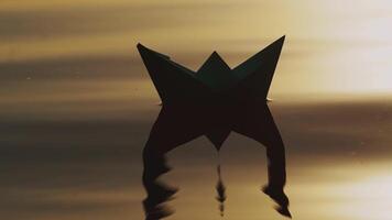 paper boat by handmade is floating on the waves of the river at sunset. The image of a paper ship is reflecting in the water in the evening video