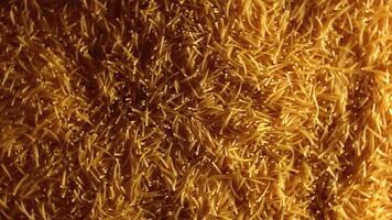 Background of Uncooked Golden Noodles that Rotating Counterclockwise - Top View. Texture of Dry Vermicelli Turning Around. Raw Pasta with Low Key Light - Left Rotation video