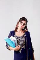 Confident Woman Model Holding Books in One Hand While Posing in Front of Camera photo