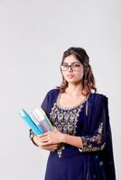 University Student in Blue Salwar Kameez Suit Holding Books in Her Hand Looks Earnestly at the Camera photo