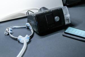 CPAP machine with nose CPAP mask and smartphone for digital app treatment stats and medical reports or health reports and digital assistant for therapy analysis and therapy reports patient files photo