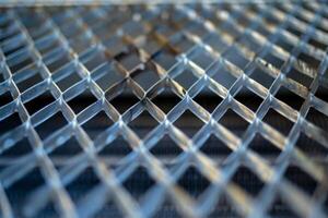 Metal grid forming repeating pattern with shallow depth of field photo