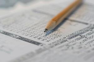 Pencil point hovering over multiple choice answers on exam paper photo
