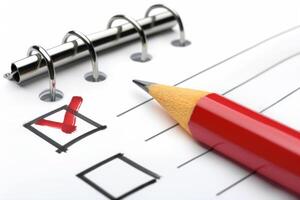 Red pencil checking off a task on checklist on a notepad photo