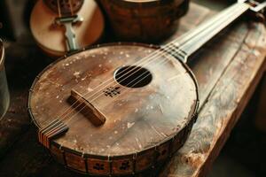 Old banjo resting on rustic wooden surface in workshop photo