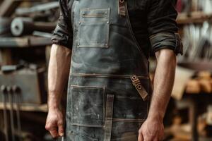 Blacksmith wearing leather apron standing in workshop photo