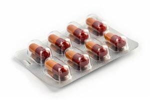 Blister pack containing red and brown pills lying on white background photo