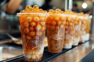 Bubble tea cups filled with tapioca pearls and tea awaiting customers in a cafe photo