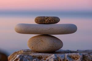 Stack of zen stones balancing on rock at sunset photo