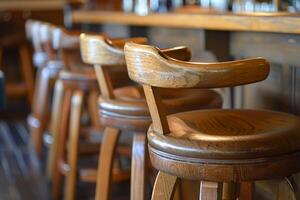 Row of classic wooden stools standing in empty bar photo