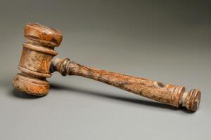 Old wooden judge gavel resting on grey surface photo