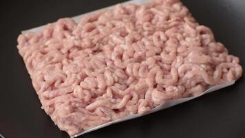Raw minced chicken with salt, spices and herbs on a dark concrete background video