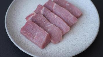 Juicy beef cut into slices with salt, spices and herbs on a dark concrete background video