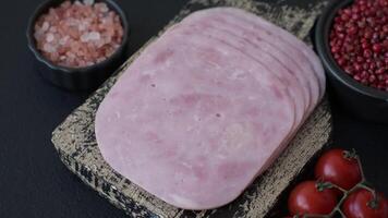 Ham, spam with salt, spices and herbs cut into slices on a dark concrete background video