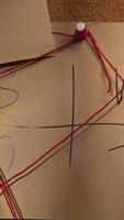 Notes with red thread. Stock footage. Close-up of mysterious notes connected by red thread. Symbols and puzzles on mysterious board with threads video