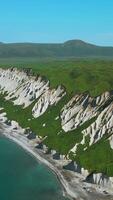 Bird eye view of calm ocean and stone rock cliffs at Oregon coast. Clip. Aerial of the ocean water surface and green meadows. video