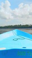Fishing boat in the river, first person view. Action. Old boat floating along green shore and blue cloudy sky on the background. video