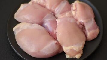 Fresh raw chicken thigh fillets with salt, spices and herbs on a dark concrete background video