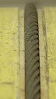 Close-Up of Textured Yellow Surfaces and Rope in an Industrial Setting with Various Elements. Stock Clip video