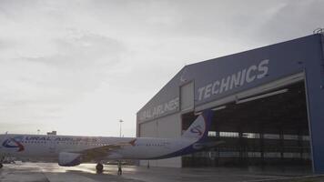 Norway, Stavanger, 08.01.2023. A calm airport scene with a plane near a hangar, symbolizing care video