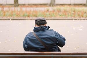 A saxophonist performs in a serene park during autumn while seated on a bench photo