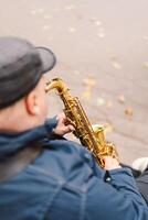 A saxophonist performs in a serene park during autumn while seated on a bench photo