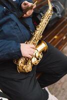A saxophonist performs in a serene park during autumn while seated on a bench photo