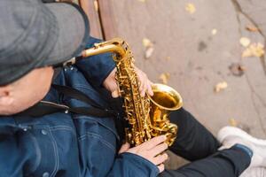 A saxophonist performs in a serene park during autumn while seated on a bench photo
