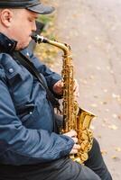 A saxophonist performs in a serene park during autumn while seated on a bench photo