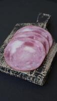 Ham cut into slices with salt and spices on a dark concrete background video