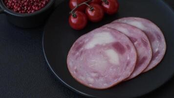 Ham cut into slices with salt and spices on a dark concrete background video