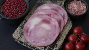 Ham cut into slices with salt and spices on a dark concrete background video
