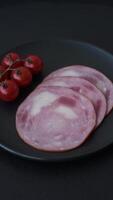 Ham cut into slices with salt and spices on a dark concrete background video